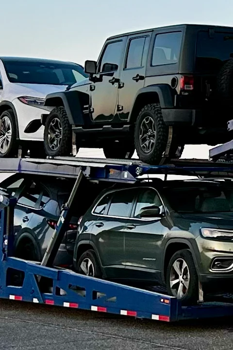Vehicles loaded on an open car carrier.