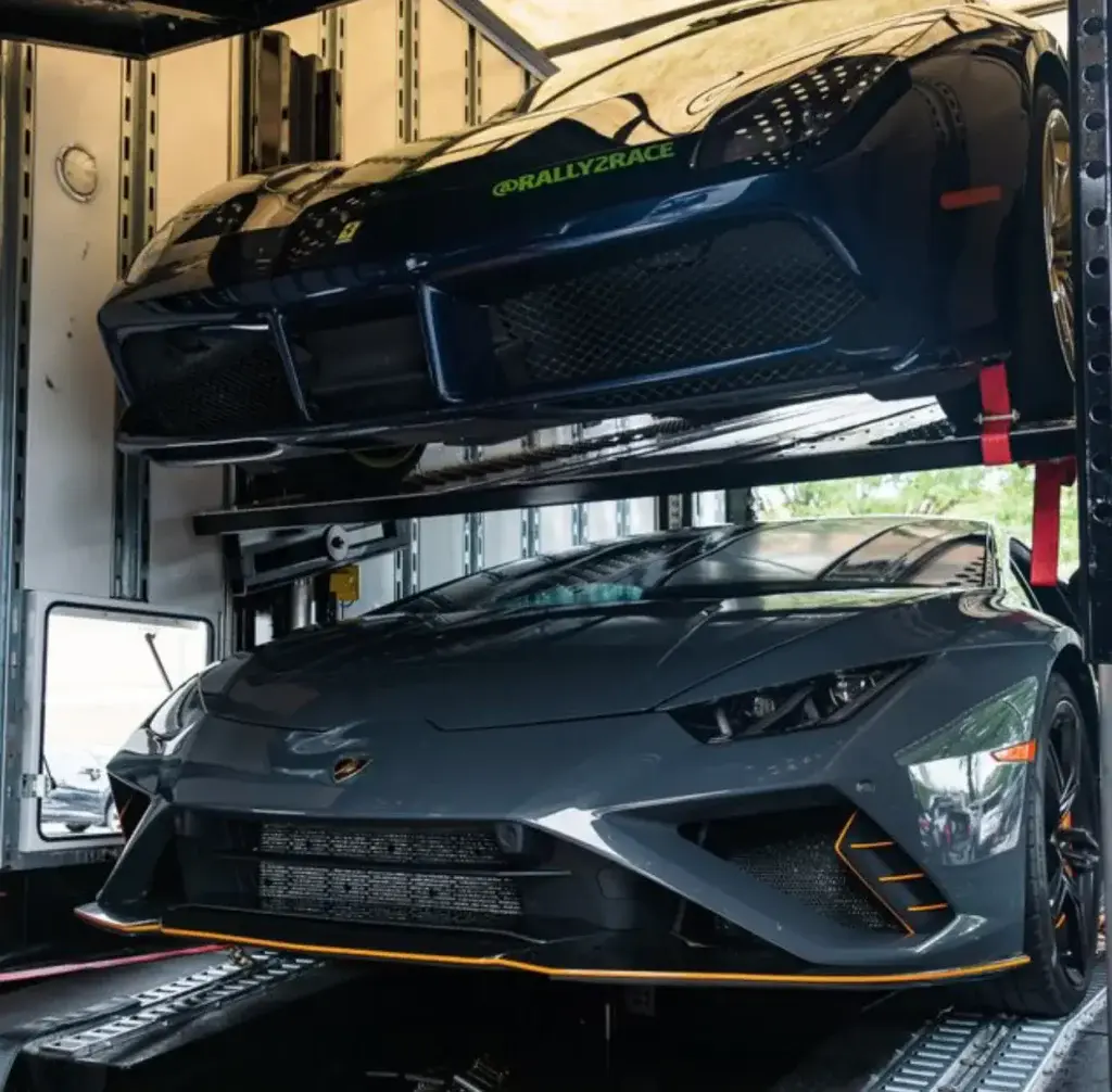 A black sports car inside an enclosed trailer.