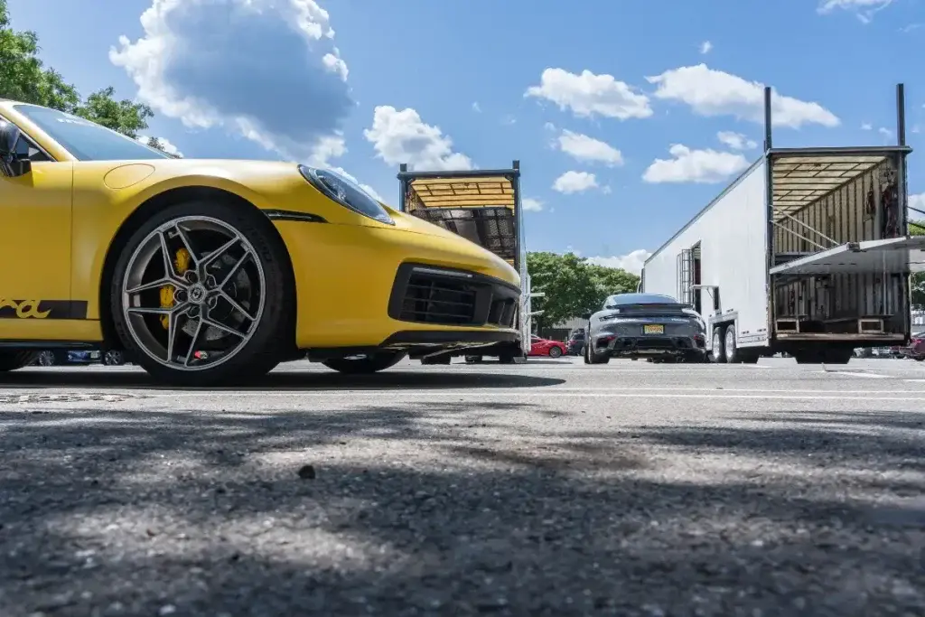 A yellow sports car being prepared for transport.